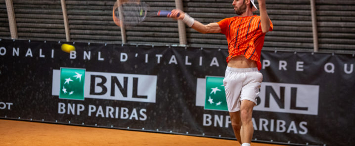 ragazzo con maglietta arancione che gioca a tennis